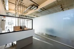 Moderne ontvangstbalie met glazen afscheiding in een strak ingericht kantoorpand aan de Fred. Roeskestraat.